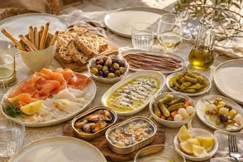 Mesa con boquerones, aceitunas, encurtidos y conservas para compartir